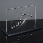 Newton pendulum van metaal met hangende bollen, wetenschappelijk decoratieobject voor bureau of woonkamer.