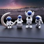 Vier astronautenfiguren als decoratie, met een maan- en bergdecor op de achtergrond, perfect voor een wetenschappelijk of ruimte-thema decoratie.