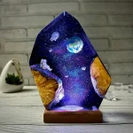 Verlicht paneel in hars met een ruimte scène, aarde, zwevende astronaut, sterren en sterrenstelsel, op een houten basis, originele decoratie voor astronomie-liefhebbers.